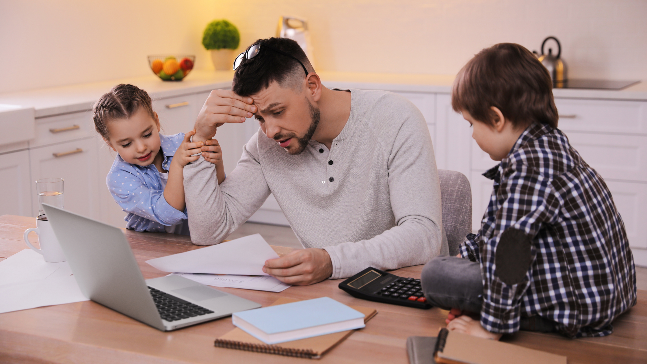 A father and two children sitting at a table discussing the cost of child care.