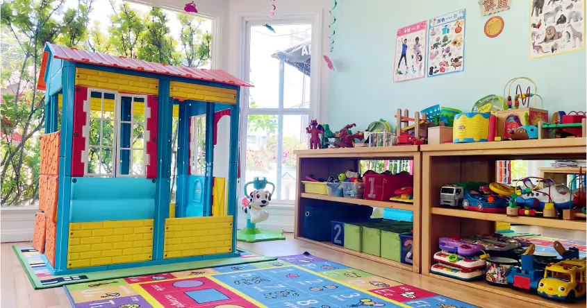 A child's playroom with a toy house and toys.